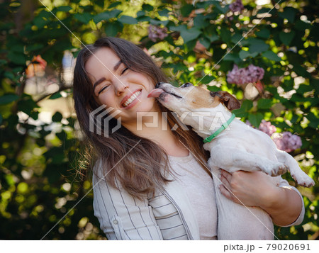 Young woman with her cute Jack Russell Terrier outdoor. 79020691