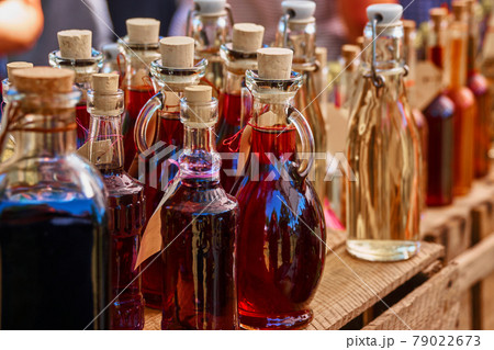 Bottles of homemade liqueur and schnapps on a wooden shelf Bottles of homemade liqueur and schnapps on a wooden shelf 79022673