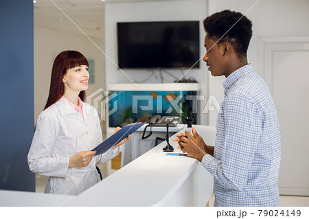 Young African man near reception desk in modern medical or dental clinic 79024149