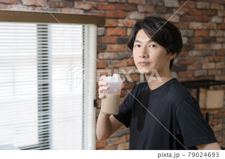 プロテインを飲む若い男性 79024693