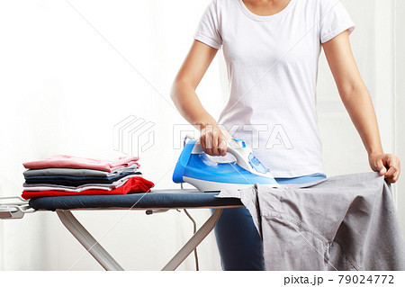 woman is ironing a shirt at home 79024772