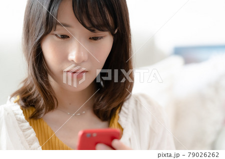 スマホを見る女性 79026262