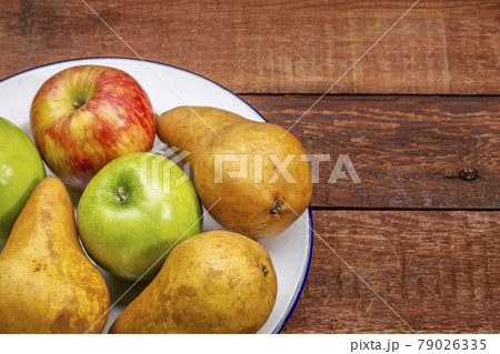 apples and pears on rustic wood table 79026335