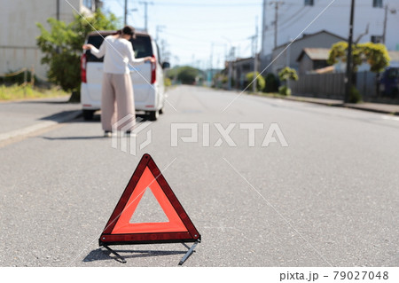 車が故障して三角停止表示版を置く女性 車が故障して三角停止表示版を置く女性 79027048