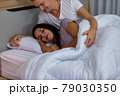 Couple lying comfortable sheets bed at night 79030350