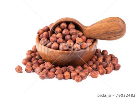 Pile of brown chickpeas in wooden bowl and spoon, isolated on white background. Brown chickpea. Garbanzo, bengal gram or chick pea bean. 79032482