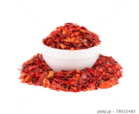 Dried red chili flakes in bowl, isolated on white background. Chopped chilli cayenne pepper. Spices and herbs. 79032483