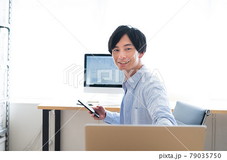 2台のパソコンとスマホを操作するエンジニアの男性 2台のパソコンとスマホを操作するエンジニアの男性 79035750