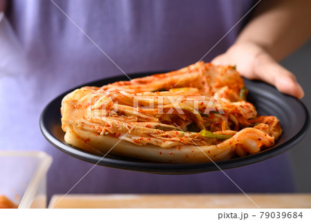Kimchi cabbage on plate holding by hand, Popular homemade Korean food 79039684