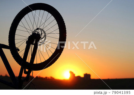 silhouette of a Bicycle wheel at sunset. 79041395