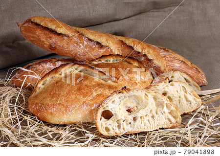 white loaves of different shapes lying in straw on grey linen tablecloth white loaves of different shapes lying in straw on grey linen tablecloth 79041898