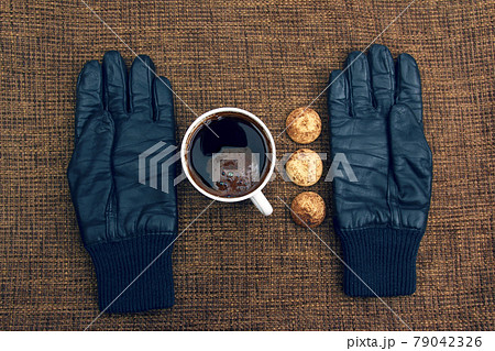 leather gloves next to a hot cup of coffee leather gloves next to a hot cup of coffee 79042326