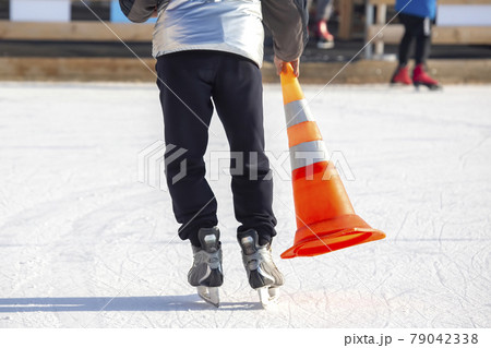 ice skating man with cone plastic safety road sign in hand ice skating man with cone plastic safety road sign in hand 79042338