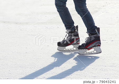 the legs of a man skating on the ice rink the legs of a man skating on the ice rink 79043241