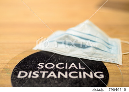 Social distancing text and face mask on table at restaurant 79046546