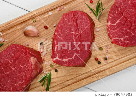 Close up raw beef tenderloin steak on board Close up raw beef tenderloin steak on board 79047902