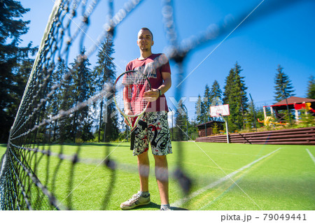 Guy plays in tennis on court in bright summer day 79049441