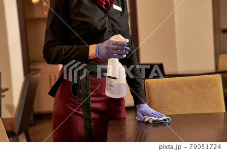 Person with cleaning detergent washing a table Person with cleaning detergent washing a table 79051724