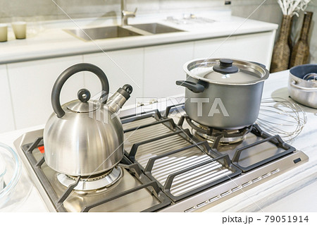 Close-up of stainless steel cooking pot and kettle boiling on gas stove in contemporary modern home kitchen. Selective focus on pot. 79051914