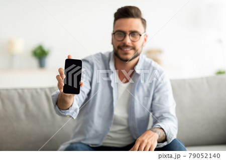 I recommend this website. Young man showing smartphone with blank screen to camera, mockup for your ad or design. I recommend this website. Young man showing smartphone with blank screen to camera, mockup for your ad or design. 79052140