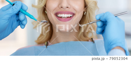 Cropped of female patient showing her white teeth, panorama Cropped of female patient showing her white teeth, panorama 79052304
