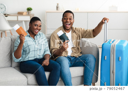 Happy Black Couple Holding Travel Tickets Posing With Suitcase Indoor 79052467