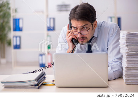 Young businessman employee unhappy with excessive work in the of Young businessman employee unhappy with excessive work in the of 79052624