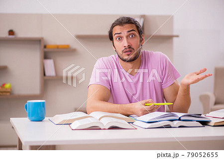 Young male student preparing for exams at home Young male student preparing for exams at home 79052655