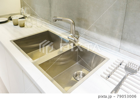 Stainless kitchen sink and Tap water in the kitchen. The interior of the kitchen room of the apartment. Built-In Appliances. Kitchen Appliance. Domestic Appliances Stainless kitchen sink and Tap water in the kitchen. The interior of the kitchen room of the apartment. Built-In Appliances. Kitchen Appliance. Domestic Appliances 79053006
