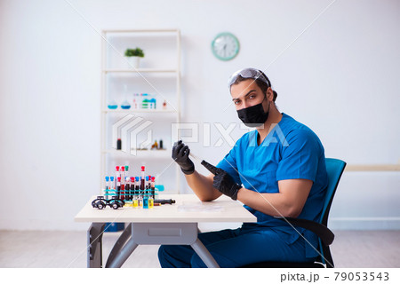 Young male biochemist testing blood samples in pandemic concept 79053543