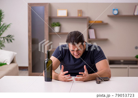 Young male alcoholic committing suicide at home Young male alcoholic committing suicide at home 79053723