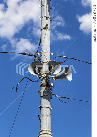 Megaphone speaker (reproducer) on the pole lighting against the sky with clouds. Moscow, Russia 79053751