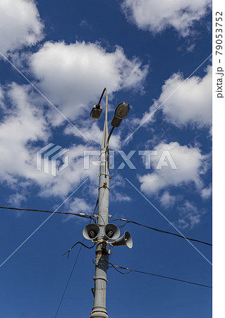 Megaphone speaker (reproducer) on the pole lighting against the sky with clouds. Moscow, Russia 79053752