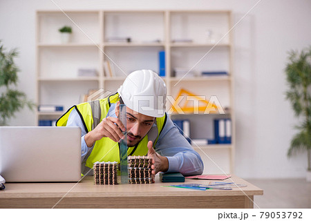 Young male architect suffering at workplace Young male architect suffering at workplace 79053792