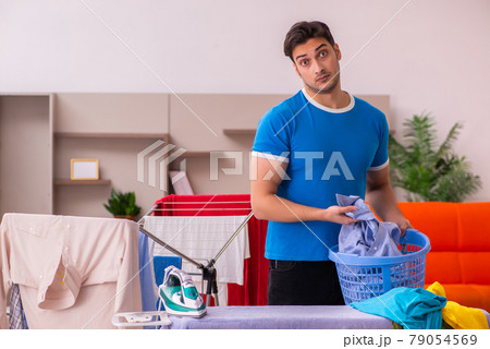 Young man husband doing ironing at home Young man husband doing ironing at home 79054569