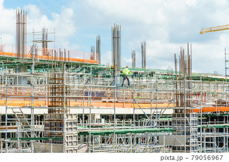 Modern building is under construction, metal scaffolding and blue sky 79056967