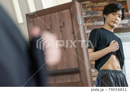 鏡でお腹の贅肉をチェックする若い男性 鏡でお腹の贅肉をチェックする若い男性 79058831