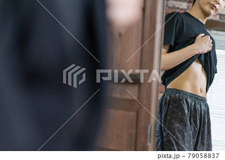 鏡でお腹の贅肉をチェックする若い男性 鏡でお腹の贅肉をチェックする若い男性 79058837