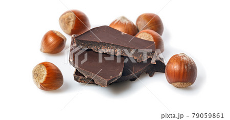 Food banner. Nuts and and dark chocolate on a white background. Ripe wild hazelnuts and bitter chocolate. Natural organic products. Copy space. Place for text. 79059861