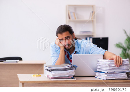 Young male employee unhappy with excessive work in the office 79060172