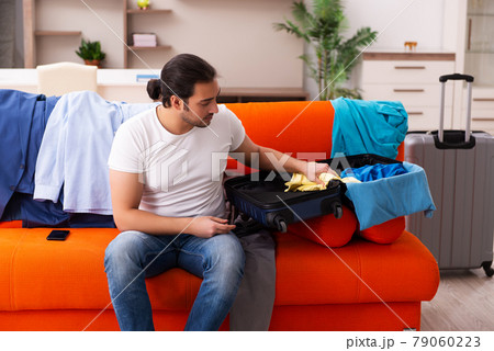 Young man student preparing for trip at home 79060223