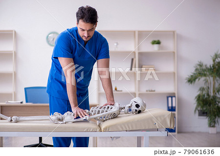 Young male doctor examining skeleton patient 79061636