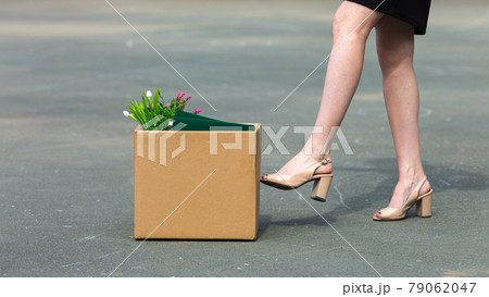 A woman's foot kicks a box of personal belongings after being fired close-up A woman's foot kicks a box of personal belongings after being fired close-up 79062047