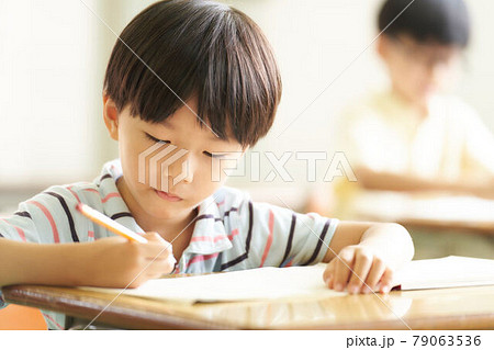 鉛筆を持って勉強中の幼い男の子 鉛筆を持って勉強中の幼い男の子 79063536