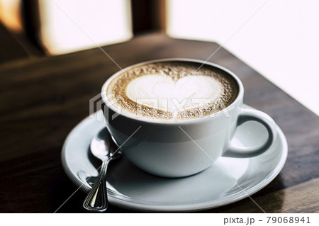 Cup of coffee latte with heart shape on old wooden background in the morning sunlight 79068941