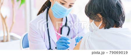 シニアにワクチンを刺す女性医師 シニアにワクチンを刺す女性医師 79069019
