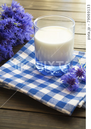 Jar of milk and cornflowers on a old brown wooden table 79069133