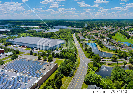Panoramic aerial view on solar panels on absorb sunlight sustainable energy of building warehouse roof near small American town Panoramic aerial view on solar panels on absorb sunlight sustainable energy of building warehouse roof near small American town 79073589