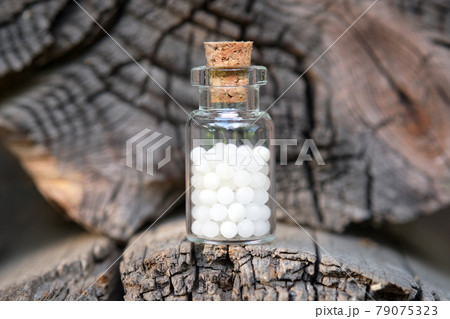 Bottle of homeopathic globules on wooden background. Homeopathy medicine concept. 79075323