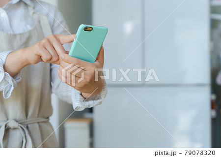 スマホを持つ女性の手元カット 79078320